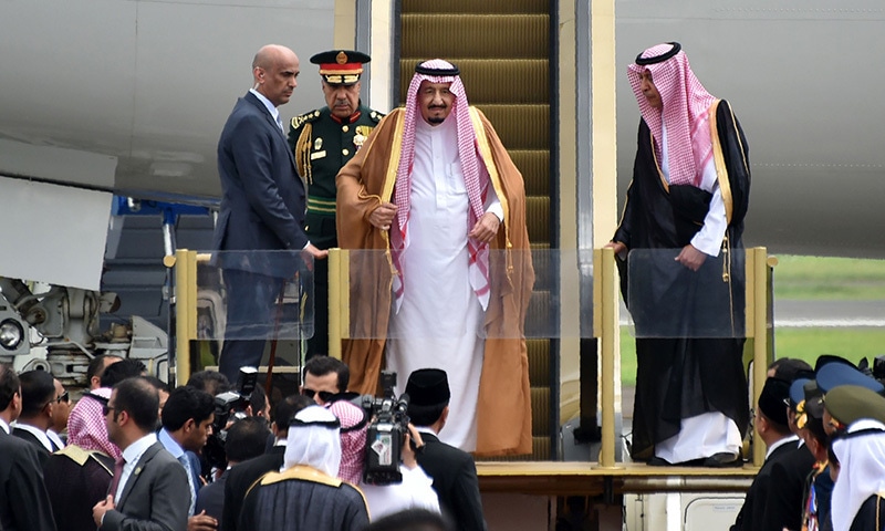Saudi Arabia's King Salman bin Abdul Aziz (C) smiles as he arrives at Halim airport in Jakarta on March 1, 2017. King Salman on March 1 began the first visit by a Saudi monarch to Indonesia in almost 50 years, seeking to strengthen economic ties with the world's most populous Muslim-majority country. / AFP PHOTO / BAY ISMOYO